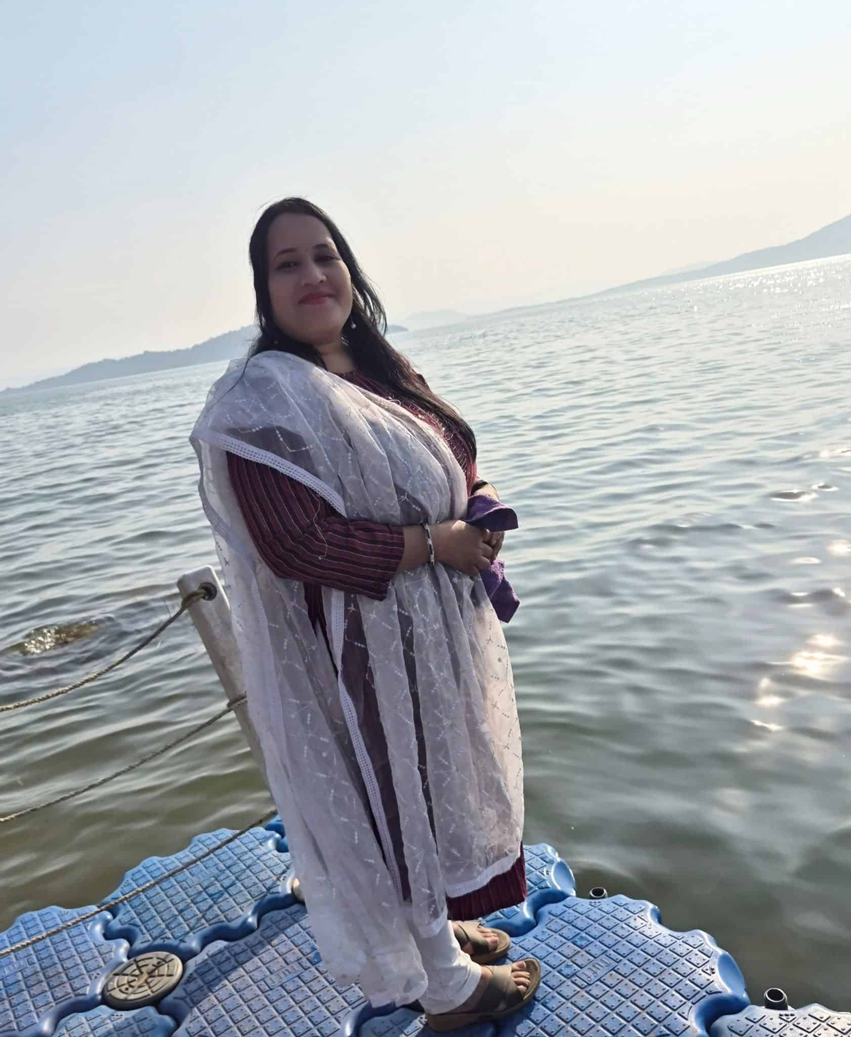 About Reena Rani Dehuri wearing a white dupatta beside the water